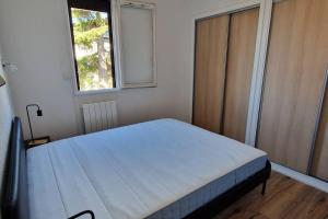 a bedroom with a bed in a room with a window at Ô Soleil - T3 à 50m de la plage des Lecques in Saint-Cyr-sur-Mer