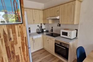 - une petite cuisine avec des placards en bois et un four micro-ondes dans l'établissement Ô Soleil - T3 à 50m de la plage des Lecques, à Saint-Cyr-sur-Mer