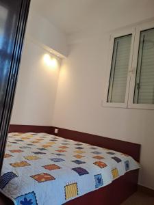 a bedroom with a bed with a quilt on it at Apartment in Punat with Terrace, Air conditioning, Wi-Fi, Washing machine (3829-2) in Punat
