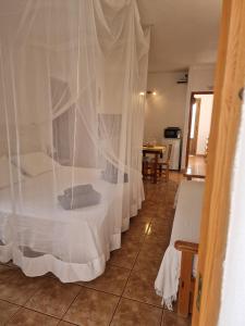 1 dormitorio con 1 cama con mosquiteras blancas en Viviendas Es Carnatge, Can Mestre en Playa de Migjorn