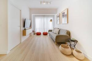 ein Wohnzimmer mit einem Sofa und einem TV in der Unterkunft Esplendido apartamento en el centro in Málaga