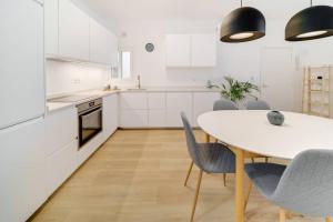 a kitchen and dining room with a white table and chairs at Esplendido apartamento en el centro in Málaga