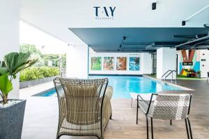 a pool with chairs and a table in a building at Tay Residence in Bangkok