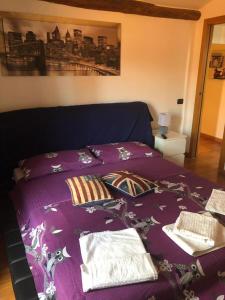 un letto con coperta viola e cuscini sopra di B&B Emc2 a Viterbo