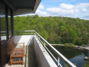 a balcony with a bench and a view of a river at Apartment Atzert in Malente