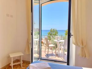 una camera da letto con porta scorrevole in vetro e vista sull'oceano di Hotel Marconi a Sperlonga