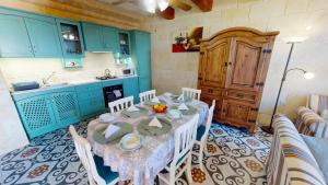 - une cuisine avec une table et des chaises dans la chambre dans l'établissement Qala Bed&Breakfast with swimming pool - IL-Wenniessa, à Qala