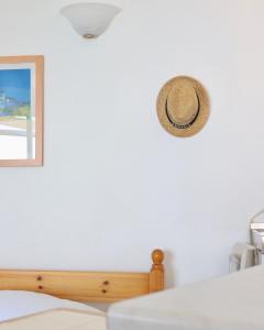 a hat hanging on a wall next to a bed at 4 Ambelia paradise in Megalochori