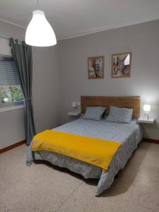 um quarto com uma cama grande e um cobertor amarelo em Apartamento vacacional en Playa del Vao - Corujo em Vigo
