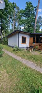 a small white house with a path in front of it at Fiołek - domek nad Szelągiem Wielkim in Ostróda
