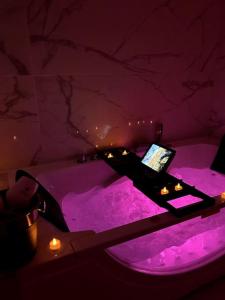 Zimmer mit einer lila Badewanne und einem Laptop darauf in der Unterkunft Love Room 80m2 BDSM 50 nuances de Grey - SAUNA - Parking gratuit in Antibes
