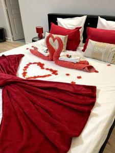 ein Bett mit zwei Schwänen aus Herzen in der Unterkunft Love Room 80m2 BDSM 50 nuances de Grey - SAUNA - Parking gratuit in Antibes