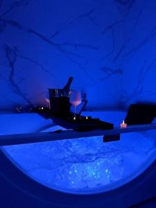 Camera blu con tavolo e bicchiere di vino di Love Room 80m2 BDSM 50 nuances de Grey - SAUNA - Parking gratuit a Antibes