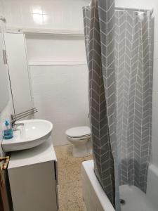 uma casa de banho com um WC e uma cortina de chuveiro em Apartamento vacacional en Playa del Vao - Corujo em Vigo