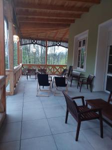 a porch with chairs and tables and a wooden ceiling at Szwajcarka in Kudowa-Zdrój