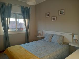 a bedroom with a bed and a window at Apartamento vacacional en Playa del Vao - Corujo in Vigo