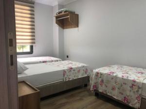 two beds in a room with white walls and a window at seyran 3 in Trabzon +6 photos