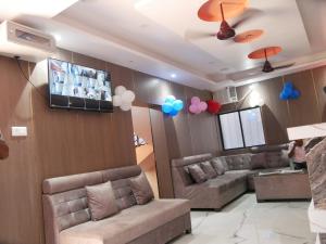德奧加爾的住宿－Vaidehi Inn-A Unit of vaidehi guest house，一间配有沙发和墙上气球的等候室