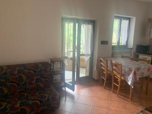 un soggiorno con tavolo, sedie e divano di Appartamenti Monterosso a Verbania