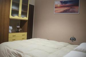 a bedroom with a white bed and a dresser at Appartamento OUT OF TIME in Valbrona