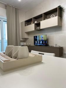 ein Wohnzimmer mit einem Tisch und Stühlen sowie einem TV in der Unterkunft Home Chiara in Bari