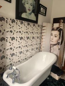 a bath tub in a bathroom with a picture on the wall at Tathan Herd in Flemingston