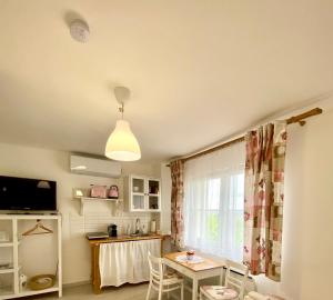 a room with a table and a kitchen with a window at BorászPorta - Présház in Villány
