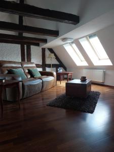 een woonkamer met een bank, een tafel en dakramen bij FeWo Lina in Waren