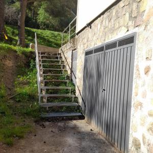 un conjunto de escaleras junto a un edificio con una puerta en Albergue La Pinilla, en Madrid