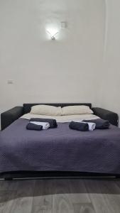 Una cama con dos almohadas encima. en La Perla di Ele en Bari