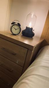 um candeeiro e um despertador em cima de uma cama em Shoreditch & Liverpool Steet Room A em Londres