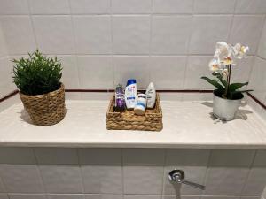 a bathroom counter with two baskets of toiletries and flowers at Shoreditch & Liverpool Steet Room A in London