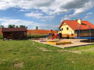 een speeltuin met een huis en een speelplaats bij Pokoje u Emilii in Mikołajki