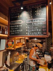 台南錦小路平屋包棟民宿 Nishikikoji inn Bungalow BnB -寵物友善-國旅卡-T aiwan Lucky Land vouchers -Nintendo Switch- NETFLIX- 一軒家貸切的在一个厨房里准备食物的人,厨房里放着黑板