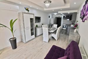 cocina y sala de estar con sofá púrpura en Apartmany Zemplinska Širava Timea en Kaluža