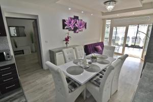 卡鲁扎Apartman Zemplinska Širava Timea的餐厅里摆放着一张白色餐桌和几把椅子。