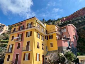 a building with pink and yellow at 5 TERRE PELAGOS 2 in Manarola