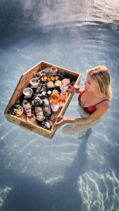 Una donna in acqua con una scatola di cibo di Brunet - The Dolomites Resort a Fiera di Primiero