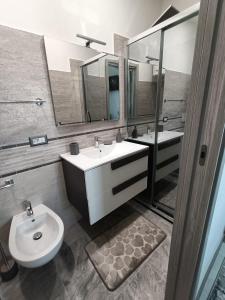 a bathroom with a sink and a toilet and a mirror at The Sunrise in San Teodoro