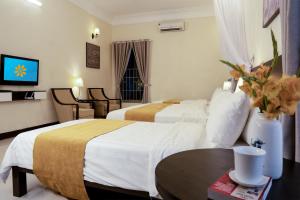 a hotel room with two beds and a table at Perfume's Cozy House in Hanoi