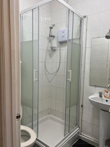 a bathroom with a shower and a toilet at parklane guest house in Cardiff