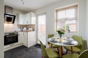 a kitchen and dining room with a table and chairs at Wrea Cottage, 2 Bedrooms WiFi & Parking near Ribby Hall in Wrea Green