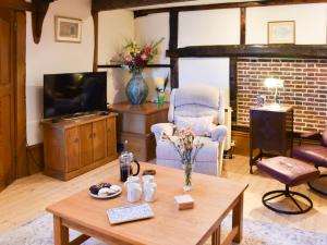 The Old Workshop في غريت يورماوث: غرفة معيشة مع طاولة وتلفزيون