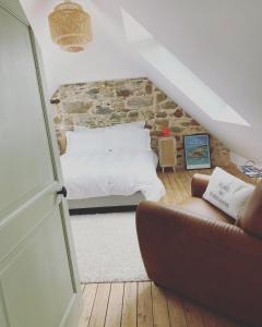 uma sala de estar com uma cama e um sofá em Les chambres de sainte barbe em Plougasnou