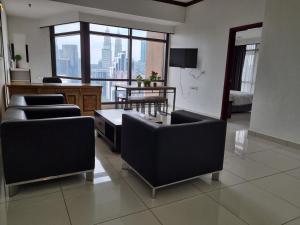 a living room with couches and a view of a city at Sunbow Suites @ Times Square Kuala Lumpur in Kuala Lumpur