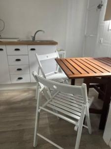 einen Holztisch und einen Stuhl in der Küche in der Unterkunft Apartamento Calvario in Rota