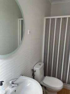 ein Badezimmer mit einem WC, einem Waschbecken und einem Spiegel in der Unterkunft Apartamento Calvario in Rota