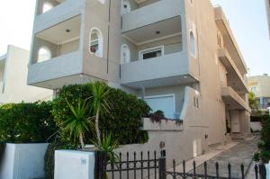 a building with a fence in front of it at Indigo in Rafina