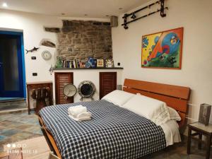 a bedroom with a bed with a blue and white checked blanket at La Casina della Tagià in Manarola