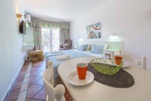 a living room with a bed and a table in a room at Apartamentos Solar do Sol in Albufeira